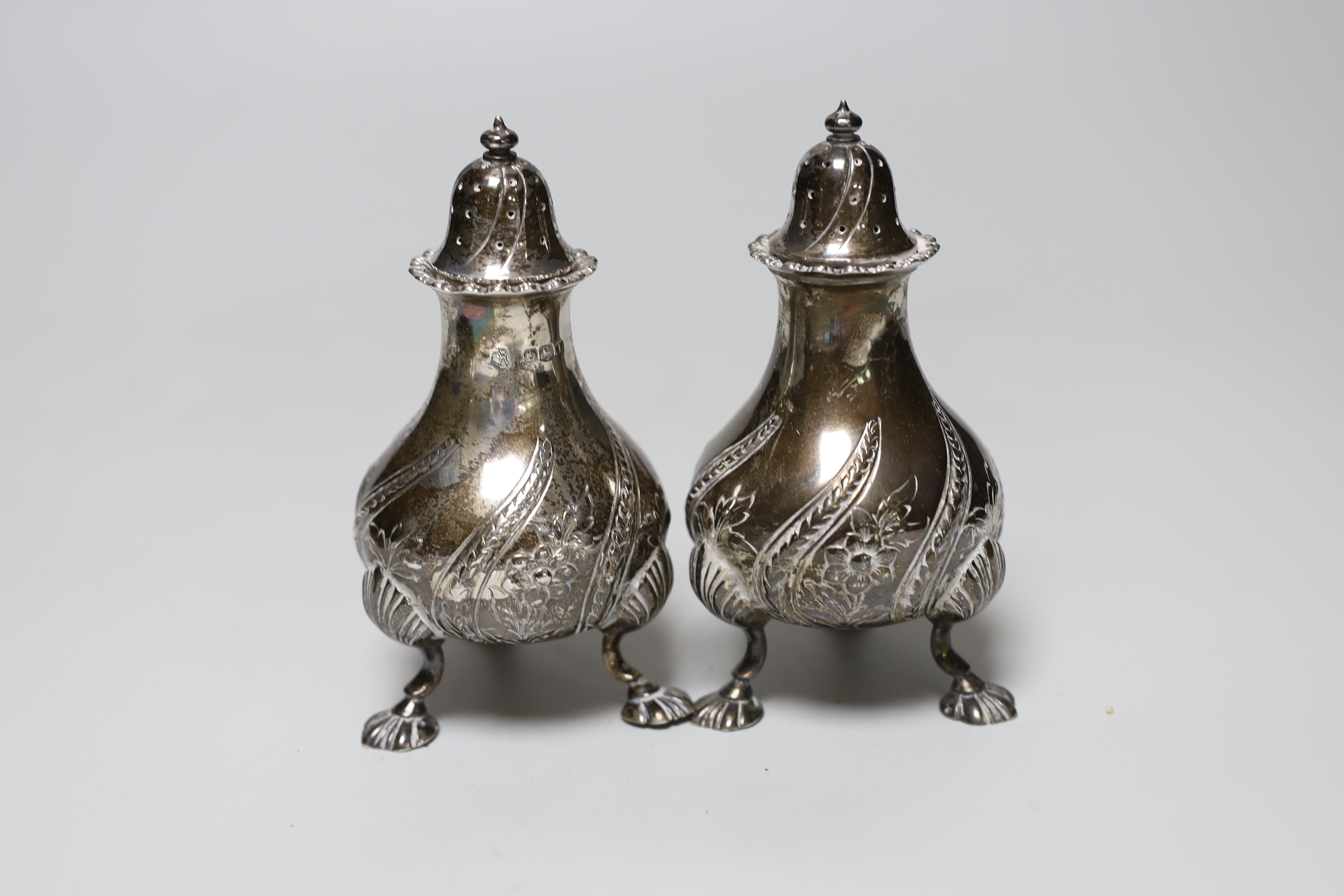 A George V five piece silver condiment set, William Hutton & Sons, Sheffield, 1928, with two associated spoons, one plated.